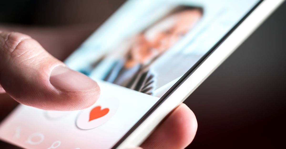 Phone with dating app up and thumb about to press heart