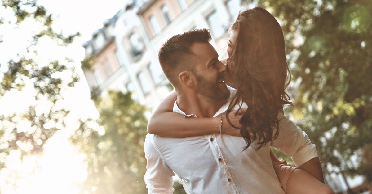 Happy couple with woman carried on back of man