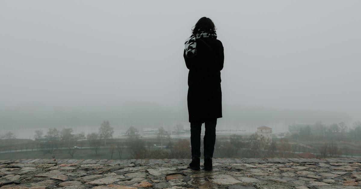 Woman standing a lone wearing black