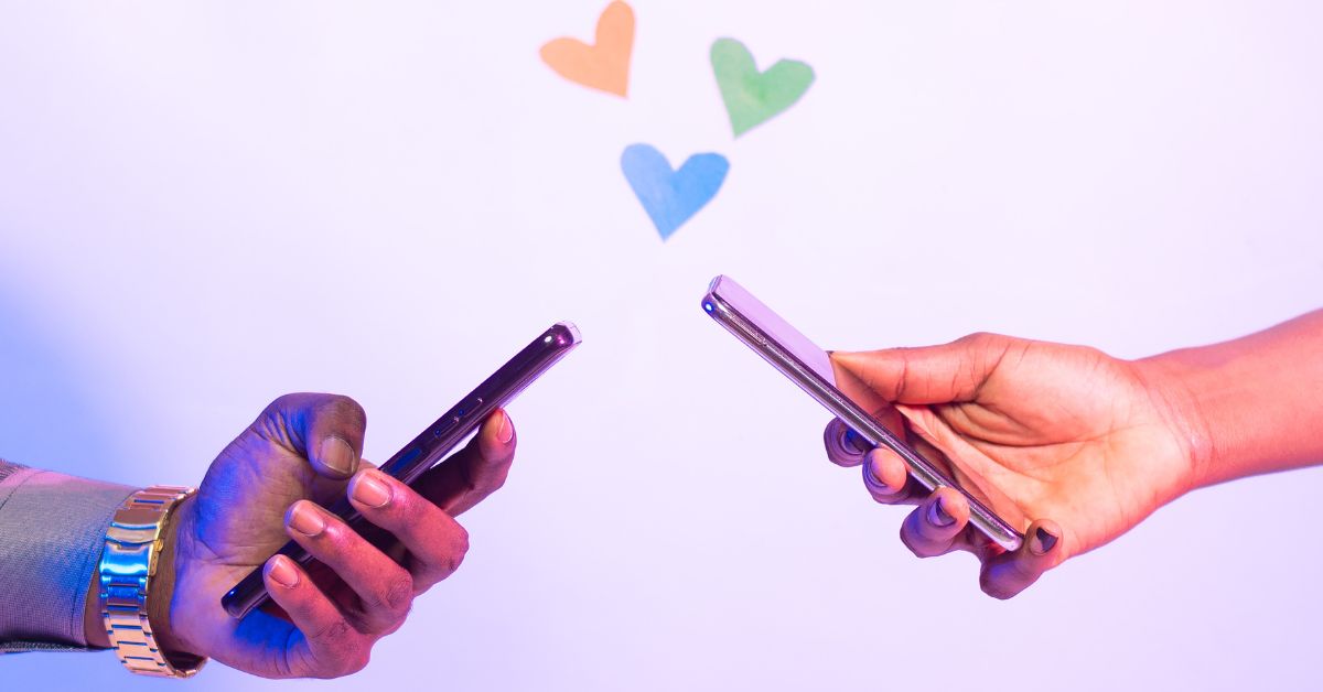 Hands holding phones with hearts between