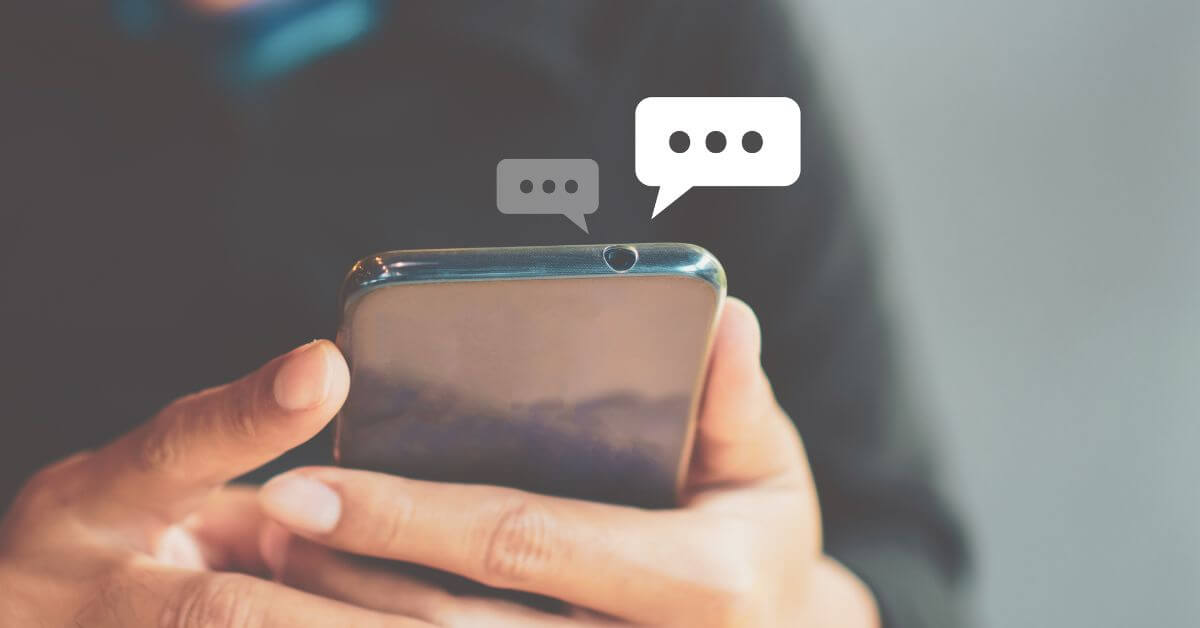 Fun online conversation topics | Hands holding a cell phone with chat bubbles around it