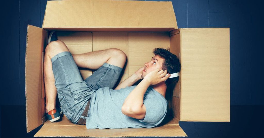 Guy laying in box with headphones | How to understand introverts on dating apps