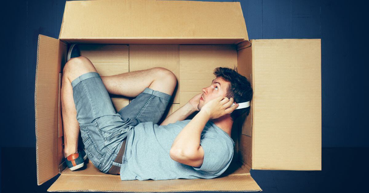 Guy laying in box with headphones | How to understand introverts on dating apps