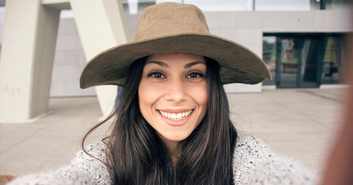 Woman wearing a hat taking a selfie | How to make yourself "pop" online