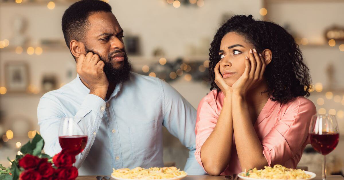 Dating after divorce | Couple at dinner table looking at each other skeptically