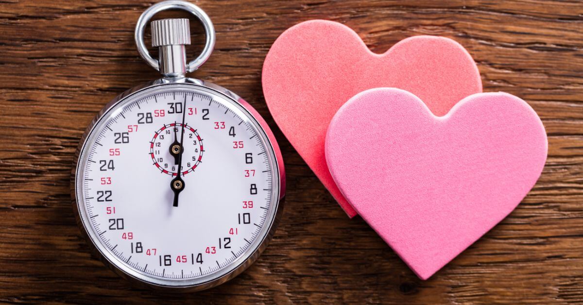 Stopwatch and hearts next to each other on a wooden surface | Do you believe in perfect timing?